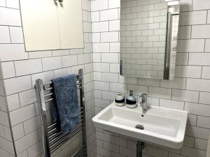 a white bathroom with a sink and a mirror at Stunning 2 bedroom Apartment in Marylebone High St in London