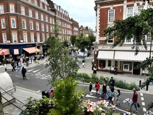 a group of people crossing a street in a city at Stunning 2 bedroom Apartment in Marylebone High St in London