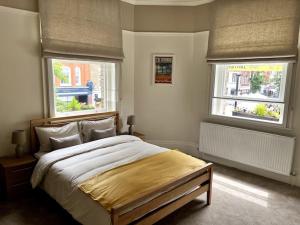 a bedroom with a large bed and two windows at Stunning 2 bedroom Apartment in Marylebone High St in London