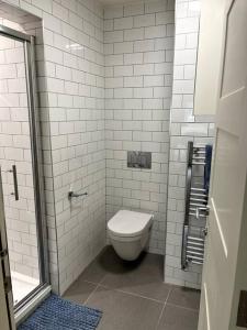 a white bathroom with a toilet and a shower at Stunning 2 bedroom Apartment in Marylebone High St in London