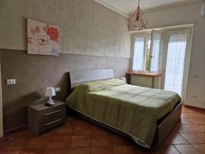 Un dormitorio con una cama y una lámpara en una mesita de noche. en Alloggio Turistico 3 minuti da aeroporto- Fiumicino centro, en Fiumicino