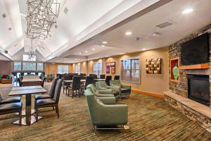 a waiting room with chairs and tables and a fireplace at Residence Inn Mt. Laurel at Bishop's Gate in Mount Laurel