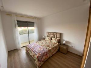 a bedroom with a bed and a window at appartements Mohammedia/mansouria in Pont Blondin
