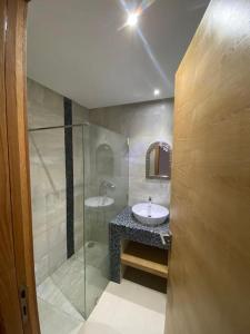 a bathroom with a glass shower and a sink at appartements Mohammedia/mansouria in Pont Blondin