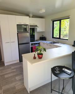 a kitchen with white cabinets and a white counter top at Private Country Cottage in Paraparaumu