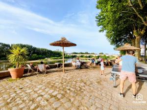 een groep mensen die in stoelen onder parasols zitten bij Terrasse et Jardin * Calme * Central * Local vélo in Orléans