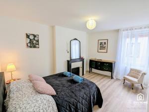 1 dormitorio con cama, silla y espejo en Terrasse et Jardin * Calme * Central * Local vélo, en Orléans