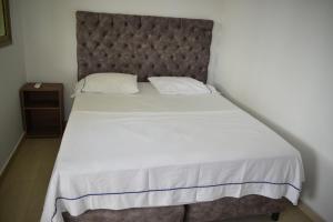 een slaapkamer met een groot bed met een bruin hoofdeinde bij Casa Campo Villa Rosa in Valledupar