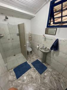 W łazience znajduje się prysznic, toaleta i umywalka. w obiekcie Casa Vila 20 - Casa para temporada em Miguel Pereira w mieście Miguel Pereira