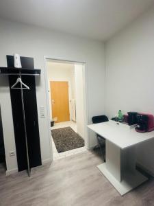 a white room with a desk and a door to a bathroom at SaNa Immobilien in Spenge