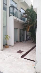 une maison avec un palmier et un balcon dans l'établissement R&L Pousada, à Cabo Frio