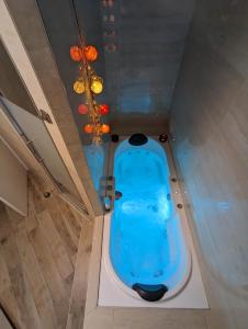- une baignoire bleue au milieu d'une pièce dans l'établissement Le Cosy-chic - T3 Balneo à Villeurbanne / Lyon, à Villeurbanne