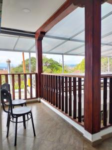 Un balcón con una silla, una mesa y vistas. en Hotel PiedradeLuna en Villa de Leyva