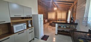 a kitchen with white cabinets and a white refrigerator at Solar das Bromélias in Arraial d'Ajuda