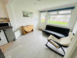 a living room with a couch and a table at 2 Bedroom Chalet SB84, Sandown Bay, Dog Friendly in Brading