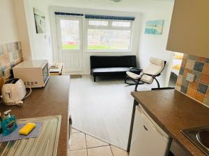 a kitchen and living room with a couch at 2 Bedroom Chalet SB84, Sandown Bay, Dog Friendly in Brading