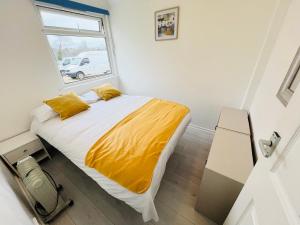 a bedroom with a bed with yellow sheets and a window at 2 Bedroom Chalet SB84, Sandown Bay, Dog Friendly in Brading