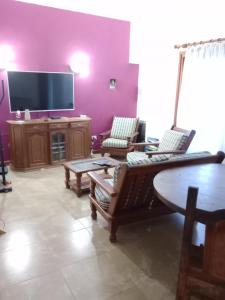 uma sala de estar com um sofá e uma televisão de ecrã plano em Santa Elena Hostal em Luján