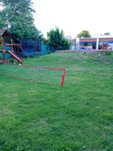 um parque infantil com uma rede na relva em Santa Elena Hostal em Luján