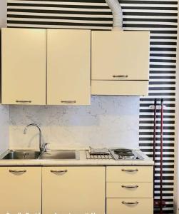 アラッシオにあるResidence Coralloの白いキャビネットとシンク付きのキッチン