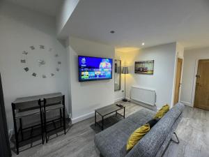 a living room with a couch and a clock on the wall at LT Apartment 62 - FREE PARKING in Leicester