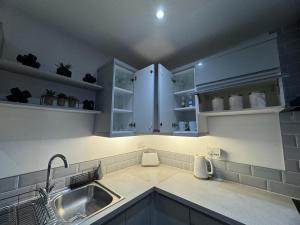 uma cozinha com armários brancos e um lavatório em LT Apartment 62 - FREE PARKING em Leicester