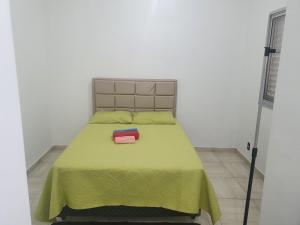 een slaapkamer met een groen bed en een groene deken bij Apto. Campolim a 100mts do shopping Iguatemi in Sorocaba