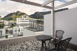 balcón con mesa, sillas y vistas en Protea Hotel Fire & Ice by Marriott Cape Town, en Ciudad del Cabo