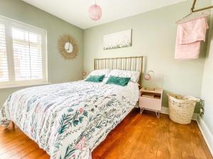 a bedroom with a bed with a green and white comforter at Beautiful 2 Bedroom Cottage with Private Courtyard in Arundel Centre in Arundel