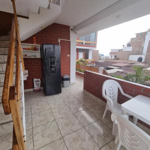 a patio with a refrigerator and a table and a chair at Mallorca in Punta Hermosa