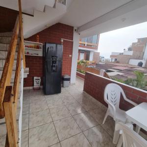une terrasse avec un réfrigérateur, une table et une chaise dans l'établissement Mallorca, à Punta Hermosa