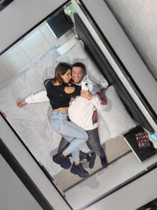 a man and a woman taking a picture on a bed at Aparta suite la nuit in Calafell