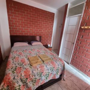 um quarto com uma cama com uma parede de tijolos em Mallorca em Punta Hermosa