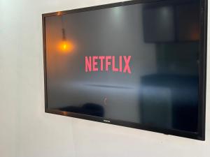 um ecrã de televisão com o sinal netflix na parede em Ház no Rio de Janeiro