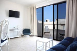 - un salon avec un canapé bleu et une grande fenêtre dans l'établissement Lindo loft en playa Marlin, 2 min de Plaza la Isla - Mar310 -, à Cancún