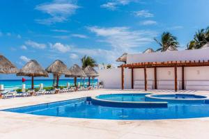 un complejo con piscina con sillas y sombrillas en Lindo loft en playa Marlin, 2 min de Plaza la Isla - Mar310 - en Cancún