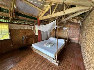 een slaapkamer met een bed in een tent bij Liberty's Community Lodge and Diving in Dumaguete