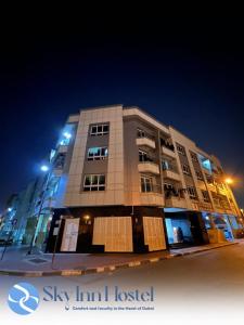 a tall building with lights on top of it at night at Sky Inn Hostel For Males in Dubai