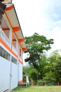 an orange and white building with a tree in the background at HOTEL REAL VILLA ISABELLA in San Agustín