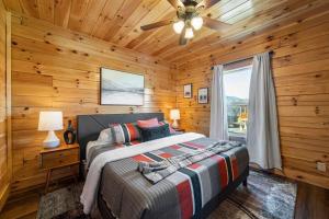 a bedroom with a bed and a ceiling fan at New Listing! Indoor Private Heated Pool, Less than 2 miles from Dollywood, Walk to Parkway, 4 Ensuite Bedrooms Sleeps 14, Dog Friendly, Game Room with TV, Arcade and Foosball, Hot Tub, BBQ, Smart TV and Wifi, Fully Loaded Kitchen, Washer and Dryer in Pigeon Forge +64 photos