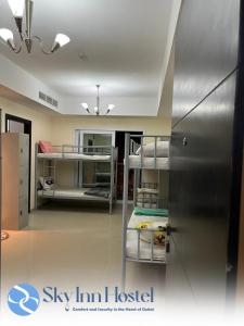 a room with bunk beds and a refrigerator at Sky Inn Hostel For Males in Dubai