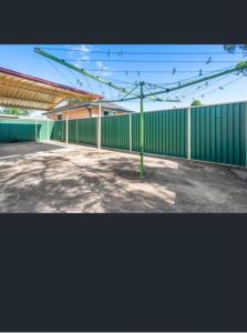 a building with a green fence with birds on it at A cosy private bedroom for you (2) in Warwick Farm