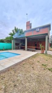 a house with a swimming pool in front of it at Cabaña LA JUANA in Villa Anizacate