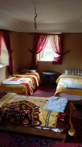 Un dormitorio con dos camas y una ventana en LODGE bennouri, en Telouet