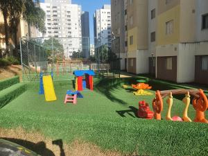 a playground with colorful play equipment on the grass at Apto. Campolim a 100mts do shopping Iguatemi in Sorocaba
