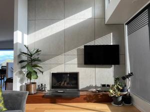 a living room with a fireplace and a tv on a wall at Fusion House in Tranmere