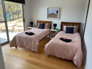 a bedroom with two beds and a window at Fusion House in Tranmere