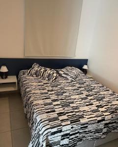 uma cama grande num quarto com 2 candeeiros em Blue Ubatuba em Ubatuba