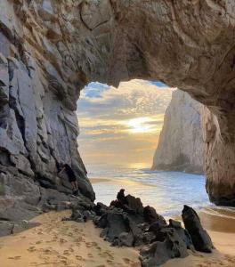 a view of the ocean through a rock cave at Loft Flor de Pitaya in Cabo San Lucas