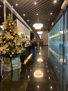 un hombre sentado en una mesa en un vestíbulo con un árbol de Navidad en Air Residences in the Heart of Makati City - Great for Tourists, Staycations or Working Professionals en Manila